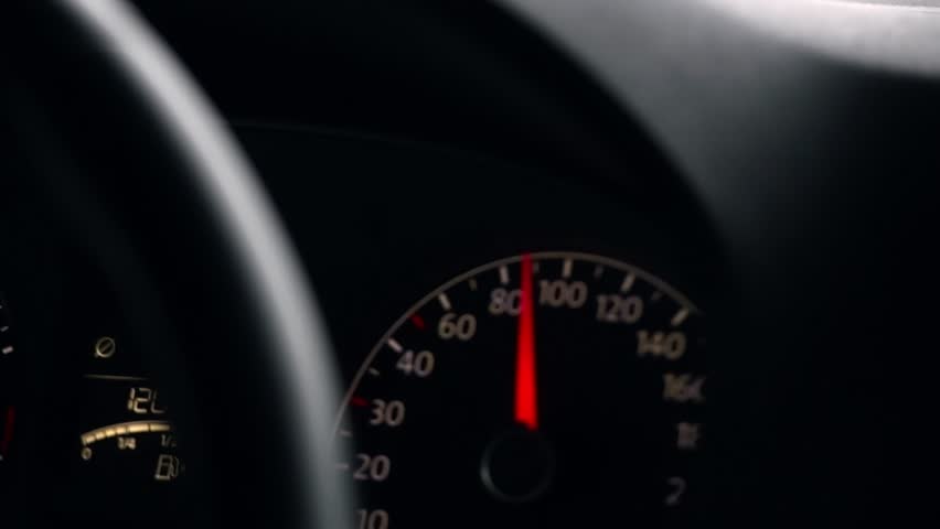 Speedometer needle gradually rises from 80 to 100 kmh, showing smooth acceleration and controlled driving on urban highway in rainy weather.