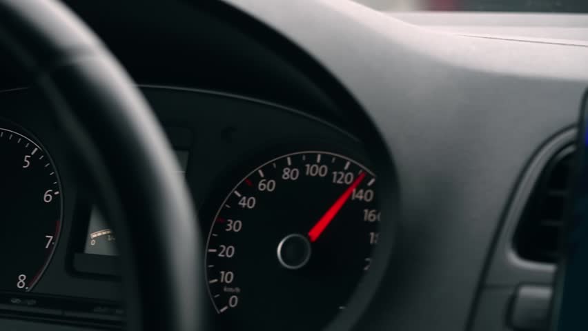 Car speedometer needle rises toward 140 kmh, illustrating dangerous acceleration and risky driving behavior inside modern vehicle.