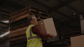 Senior worker reaching for box and lifting on pallet with network icons mapping warehouse data. Industrial, logistics, connectivity, digital, warehouse, automation, efficiency - Powered by Shutterstock - Get 15% off with code: PIKWIZARD15