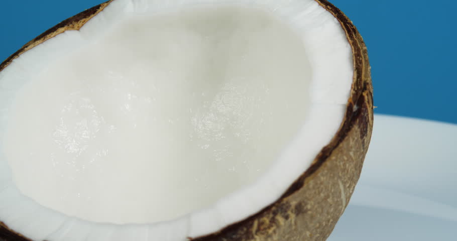 Ripe Tropical Coconut Halve Rotating on a Blue Background