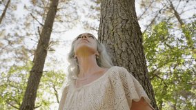 A peaceful senior woman enjoys quiet time in a forest, connecting with nature's tranquility and inner peace. - Powered by Shutterstock - Get 15% off with code: PIKWIZARD15