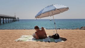 Man Tourist Enjoying a Relaxing Day at the Beach, Comfortably Seated Under a Bright Umbrella, Barcelona, spain. - Powered by Shutterstock - Get 15% off with code: PIKWIZARD15