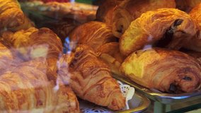 Golden brown pain au chocolat filled with dark chocolate displayed on a tray in a Parisian bakery, tempting passersby with their delicious aroma - Powered by Shutterstock - Get 15% off with code: PIKWIZARD15