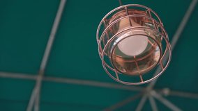 Close-up of Vintage Industrial Hanging Light Fixture Against Teal Ceiling Structure in Modern Indoor Space - Powered by Shutterstock - Get 15% off with code: PIKWIZARD15