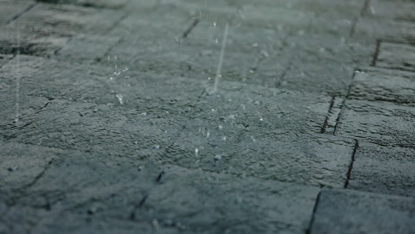 Hailstones scattered on a roof with soft bitumen shingles during a heavy rain shower, showing wet surfaces and water flow. High quality 4k footage