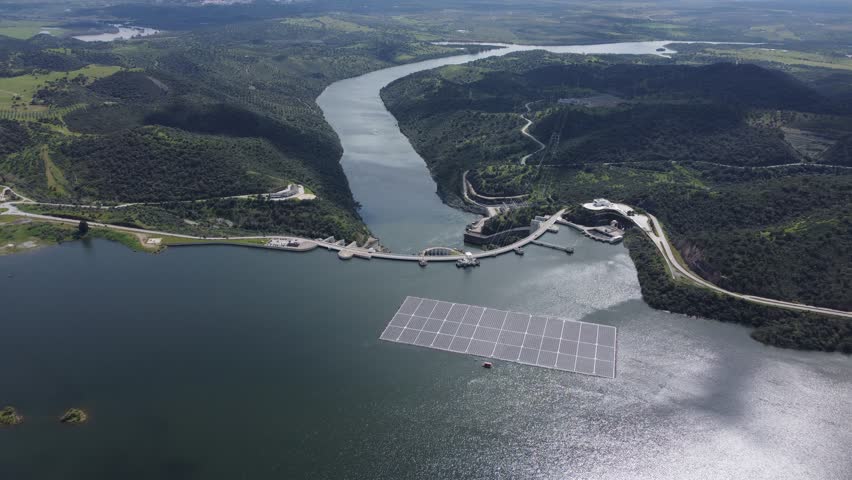 Drone view of Alqueva Dam at full capacity with floating solar panels on the water, shot in Alentejo, Portugal.