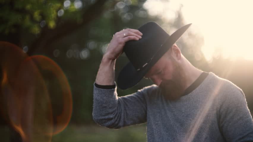 cowboy man in hat with red beard in sunlight