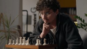 Thoughtful Caucasian man guy grandmaster playing chess at home male ponder brainstorm hipster thinking through tactics player enjoy chessboard mind game tournament moving piece knight checkmate sport - Powered by Shutterstock - Get 15% off with code: PIKWIZARD15