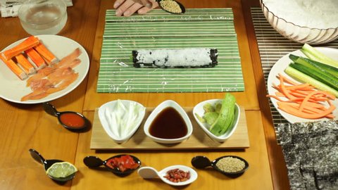 Making Uramaki Sushi roll with sesame seeds