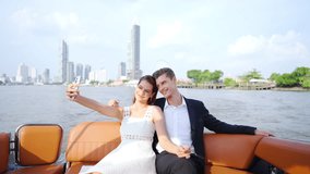 Happy Caucasian couple enjoy urban lifestyle using mobile phone taking selfie together while travel city on luxury private boat yacht sailing in the river celebrating holiday event on summer vacation. - Powered by Shutterstock - Get 15% off with code: PIKWIZARD15