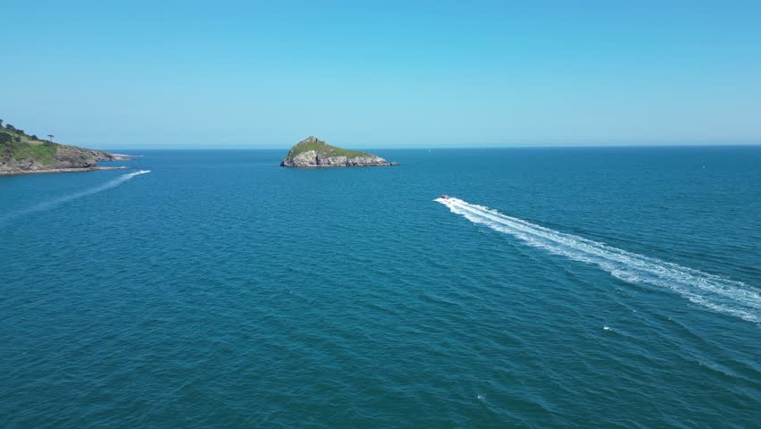 Torbay, South Devon, England: DRONE VIEWS: A speedboat heads across the bay in the direction of Thatcher Rock. Torbay is a popular UK holiday destination and retirement area (Clip 2 of 4)
