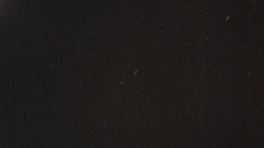 Classic 8mm film overlay featuring a near-black base with faint grain, subtle scratches, and occasional tiny dust particles, where deep darkness enhances dramatic and slightly distressed analog feel