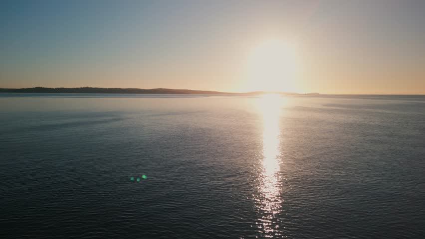 Cinematic drone shot The Rowing Team Glides Smoothly Over Halifax Bay As The Sun Rises. Captured From Above, Their Rhythm Forms Ripples Across The Quiet Surface.