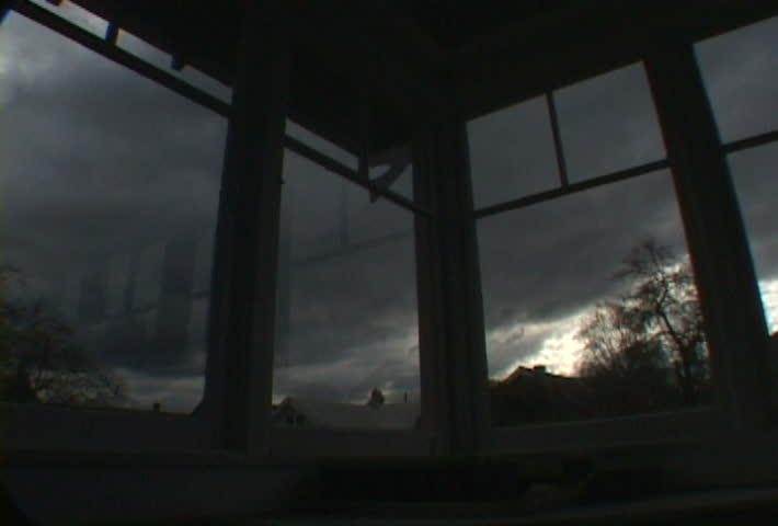 Interior house looking out windows as storm develops.