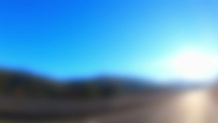 A soft-focus time-lapse video of a sunny highway with strong blur and glow. The image is intentionally out of focus, making it ideal for use as a modern background, aesthetic transition, or text overl