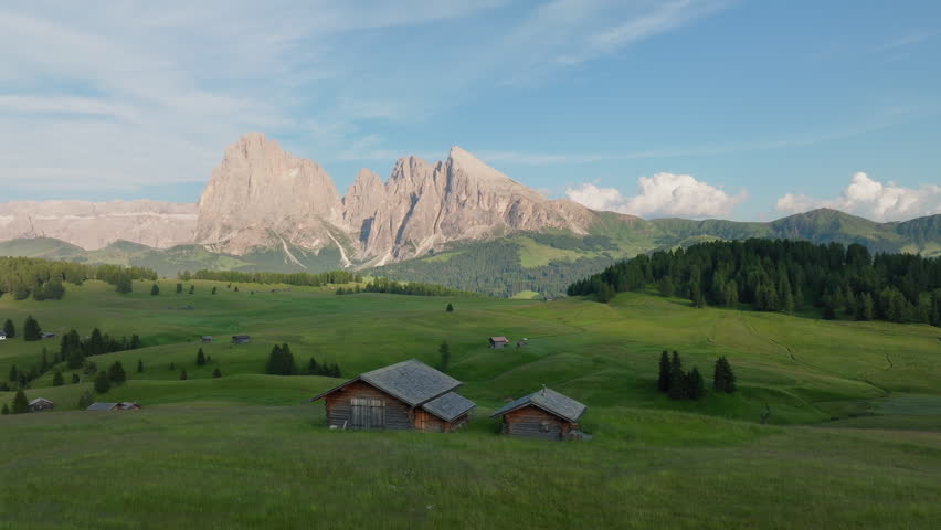 Alpine huts, mountain inns on Alpe di Siusi, high altitude plateau in the Dolomites alps at sunset, Panoramic view, Drone shot