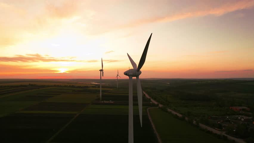 Windmill turbines generating green energy electricity at sunset.Green energy helps reduce carbon emissions and makes the earth cleaner and more ecological. Ecology technology industrial.