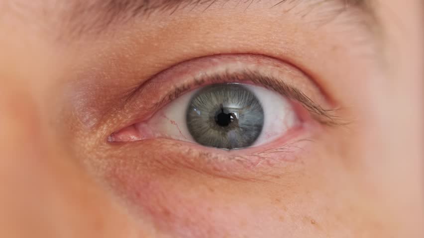 Caucasian male moving blue eye. Close up macro shot, natural light, slow motion