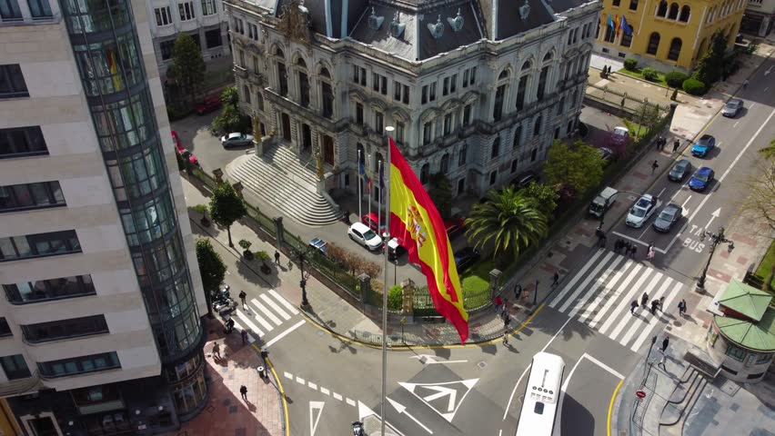 Video of the centre of Oviedo with the Spaniard flag moving with the wind. Beautiful drone shot