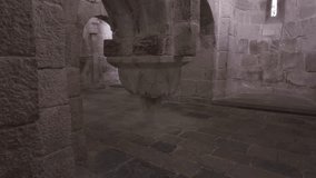 Horizontal footage moving upward from the stone floor to the vaulted ceiling inside the crypt of Leyre Monastery in Spain. The video reveals a decorated column, Romanesque arches, and a absidiole - Powered by Shutterstock - Get 15% off with code: PIKWIZARD15