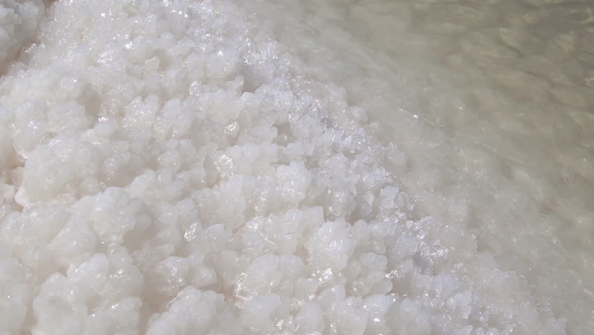 Close-up view of white salt crystals accumulating along the shallow edge of the unique Dead Sea, Jordan.