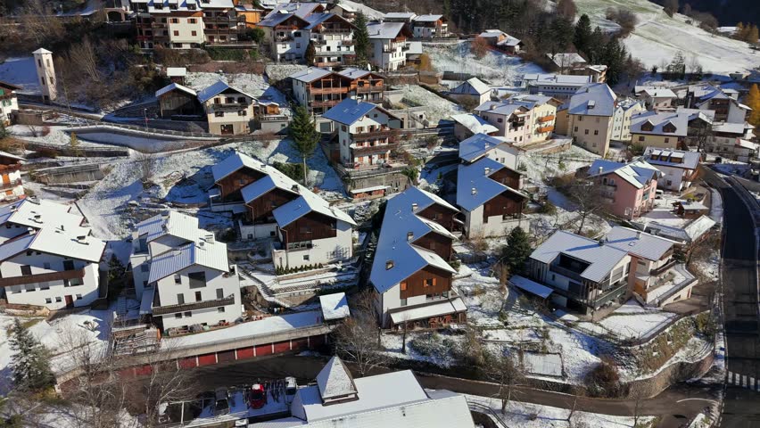 Low altitude aerial footage of Tiers Tires in South Tyrol Alto Adige Italy showing rooftops buildings narrow streets and snow covered ground in a traditional alpine mountain village