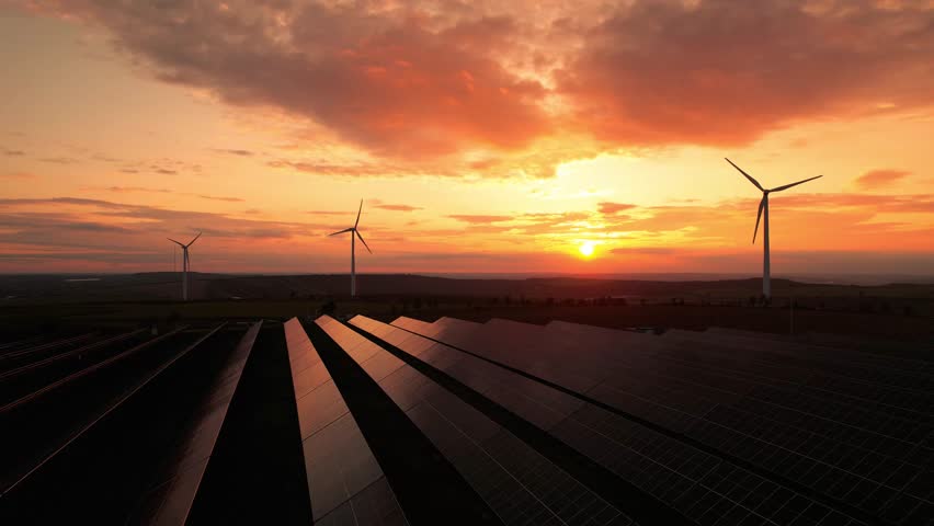 Green energy helps reduce carbon emissions and makes the earth cleaner and more ecological.Ecology technology industrial.Aerial view of windmill turbines generating green energy electricity at sunset.