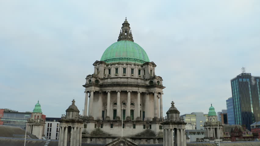 Dynamic drone pullback from Belfast City Hall dome revealing iconic building's grand architecture
