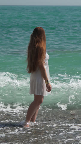 Woman Ocean Waves long hair woman standing in ocean water on beach Vertical video