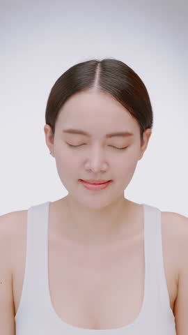 Vertical clip. Portrait of a young Asian girl with light makeup and perfect skin. Beautiful face of young woman with natural skin.