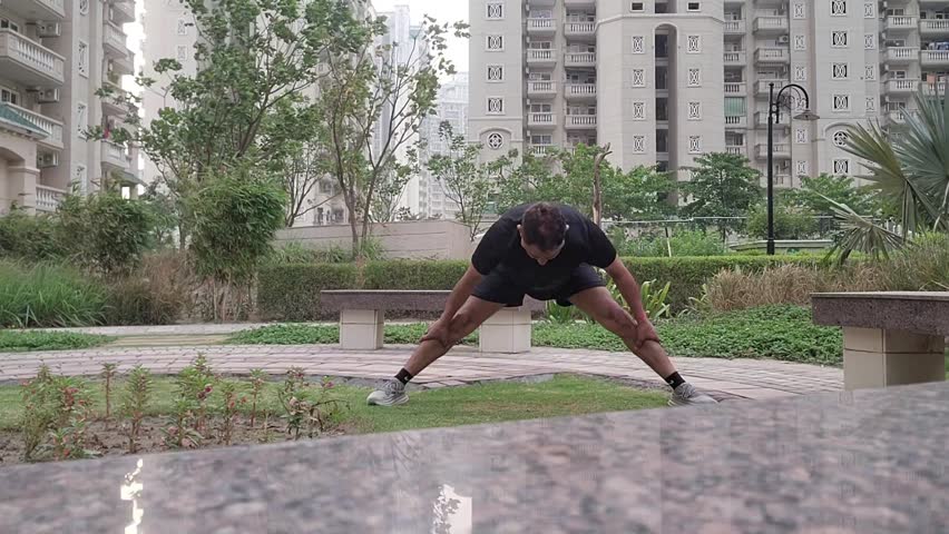 Corporate executive doing exercise in the garden, urban lifestyle.