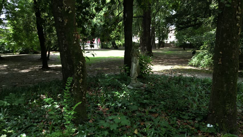 A small woman statue inside a green forest