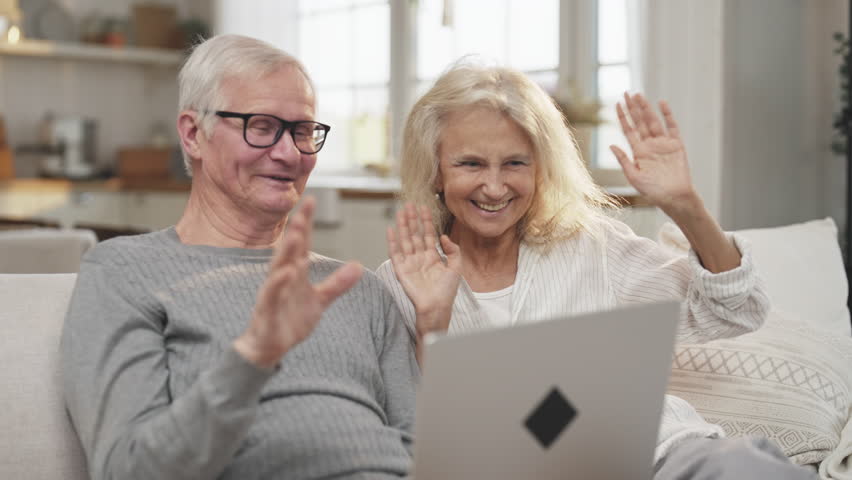 Elderly people using laptop for video call and communication with family at home . Portrait of cheerful aged man and woman chatting online with friends, happy old lady and her husband spending time