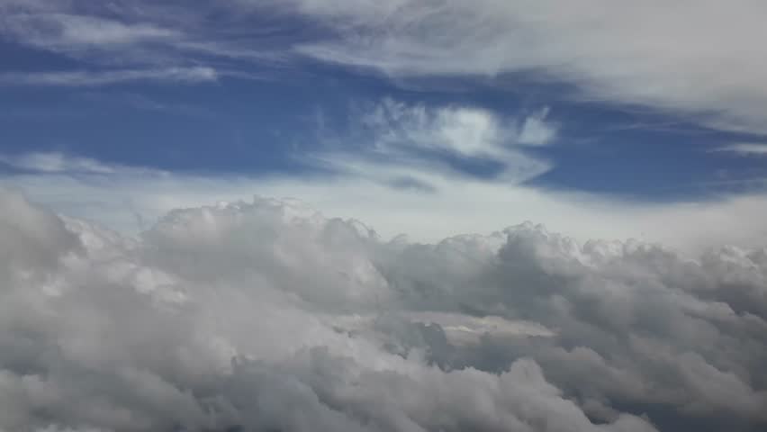Cinematic footage flying through a breathtking cloudscape, captured from a jet cockpit flying through layers of ethereal clouds. 4K