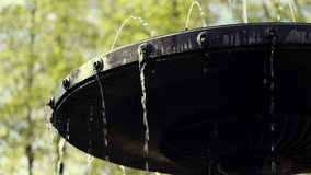 Close Up Of Water Dripping And Spouting From Small Orifices On An Ornate Metal Fountain Tier. Green Trees In Soft Focus Background. Park Or Garden Feature. - Powered by Shutterstock - Get 15% off with code: PIKWIZARD15