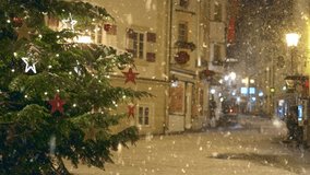 Snow falls in the city during the Christmas and New Year holidays. Snow falls over decorated streets in charming town square during holiday season. Winter in the city - Powered by Shutterstock - Get 15% off with code: PIKWIZARD15