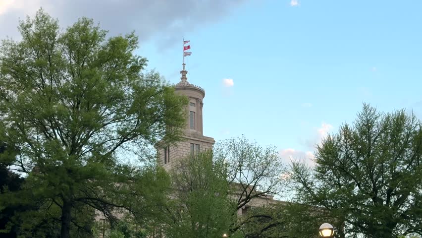 The Tennessee State Capitol building in Nashville, Tennessee with the United States flag, the Tennessee state flag