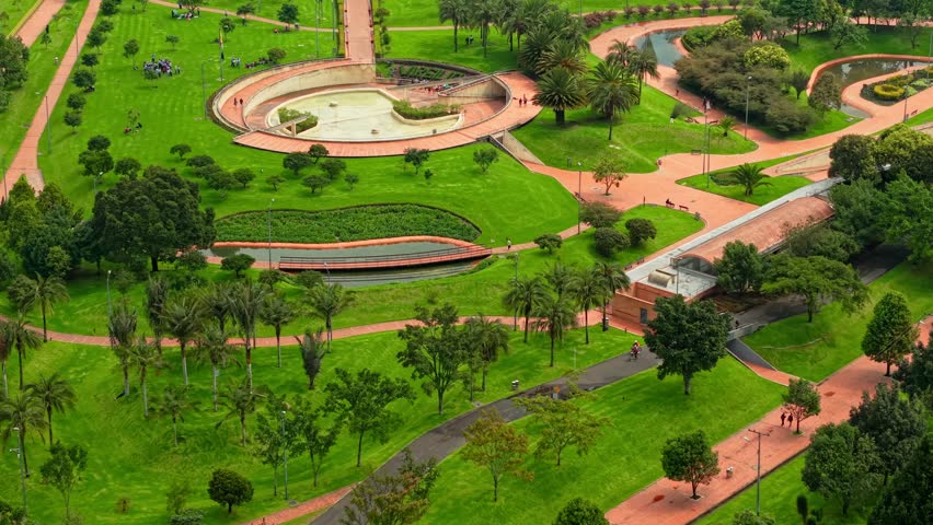 Aerial orbit of a cyclist and people jogging and enjoying the outdoors at Virgilio Barco Park in Bogota, Colombia. Natural green environment