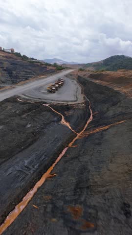 Open-pit gold and silver mine, Barrick Gold, Cotui, Dominican Republic. Aerial drone FPV. Vertical format, copy space