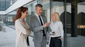 Businesspeople discussing renewable energy investment with a wind turbine model outdoors - Powered by Shutterstock - Get 15% off with code: PIKWIZARD15