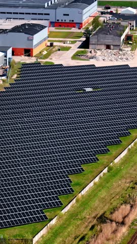Commercial buildings and solar panel fields, aerial vertical view