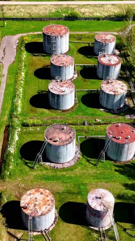 Old and rusty silos for liquid storage, aerial drone view