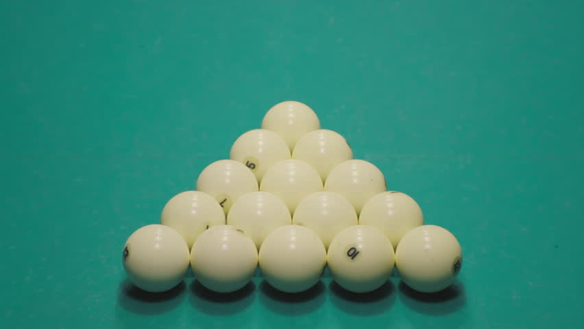 Billiard player breaks a pyramid or triangle of white billiard balls, starts the game. Green table
