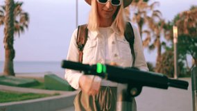Young woman use smartphone app to unlock an electric scooter by seaside, preparing for ride along scenic pathway lined with palm trees.Travel, blogging, weekend, relax and lifestyle - Powered by Shutterstock - Get 15% off with code: PIKWIZARD15