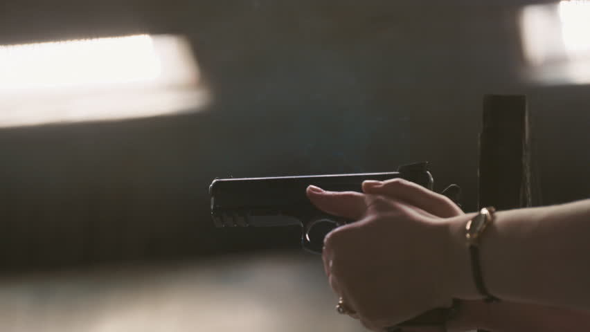 Close-up: men's hands fire a firearm. The gun is in the shooting range, the cartridge case is flying out, slow motion. Real gun, shot from hand, pistol