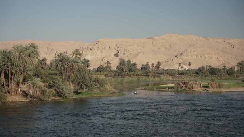 View of scenery and cruise boat from a cruise boat sailing on the Nile River between Luxor and Edfu on sunny day, Luxor, Egypt, Africa
