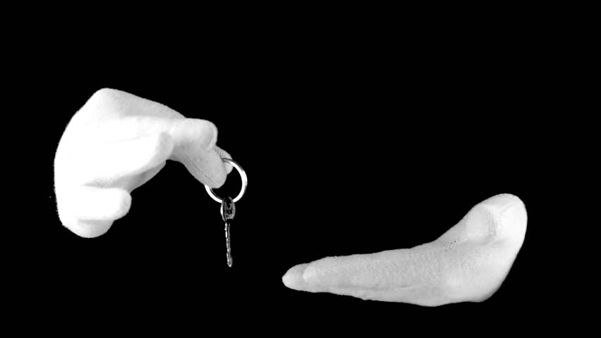 Black background. White-gloved hands manipulated with the key on the ring