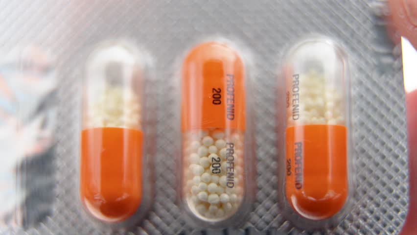 close up of three orange profenid 200mg capsules in blister pack with visible granules