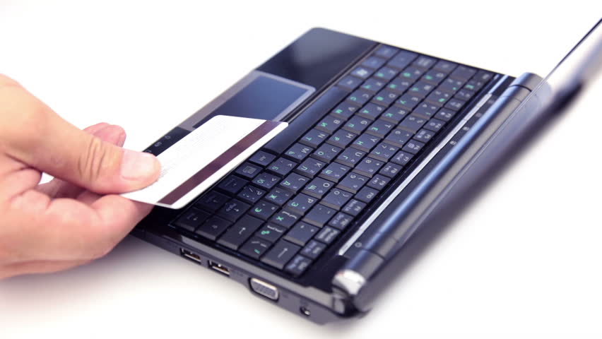 White background. Laptop. Men's hands are gaining credit card number on the