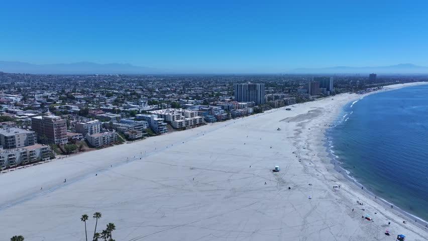 LONG BEACH, CALIFORNIA - 9 MAY 2025: Aerial city Long Beach California beach to marina pull fast. Long Beach coastal city, Los Angeles cargo container ship terminal Asian and China trade. Cityscape.